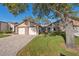 Charming single-story home with a brick driveway, two-car garage and mature trees at 7414 Heather Walk Dr, Weeki Wachee, FL 34613