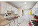 Practical kitchen with white cabinets, appliances, and adjacent laundry area for convenience at 7414 Heather Walk Dr, Weeki Wachee, FL 34613