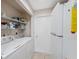 Efficient laundry room with modern washer, dryer, and storage shelves at 7414 Heather Walk Dr, Weeki Wachee, FL 34613