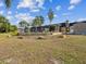 Large backyard featuring screened-in porch, patio with potted plants, and mature landscaping at 7815 Tanglewood Dr, New Port Richey, FL 34654
