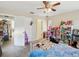 A cozy bedroom featuring a ceiling fan, blue accents, and an open doorway to the kitchen at 7815 Tanglewood Dr, New Port Richey, FL 34654