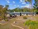 A ranch-style home has meticulously landscaped front yard with decorative garden beds and mature trees at 7815 Tanglewood Dr, New Port Richey, FL 34654