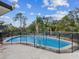 Backyard view of a fenced in outdoor pool surrounded by tropical landscaping at 7815 Tanglewood Dr, New Port Richey, FL 34654