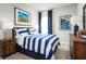 Comfortable bedroom with a striped comforter, surf decor, and dark wood furniture at 10008 Zennia Ln, Parrish, FL 34219