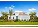 Beautiful two-story home with well-manicured lawn, tropical trees and vibrant landscaping at 10008 Zennia Ln, Parrish, FL 34219