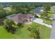 Overhead view of house with well manicured lawn, mature trees, and three car garage at 10124 Southern Breeze Ct, Weeki Wachee, FL 34613