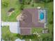 Aerial view showcasing a home with a screen enclosed pool, fenced yard, and mature trees at 10124 Southern Breeze Ct, Weeki Wachee, FL 34613