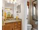 Bathroom featuring granite countertops, framed mirror, and toilet room with decorative wallpaper at 10124 Southern Breeze Ct, Weeki Wachee, FL 34613