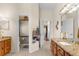 Bright bathroom featuring double sink vanities with granite countertops and an adjacent toilet room at 10124 Southern Breeze Ct, Weeki Wachee, FL 34613