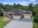 Spacious home with three car garage, concrete driveway, manicured lawn, and mature landscaping at 10124 Southern Breeze Ct, Weeki Wachee, FL 34613