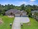 A well-manicured lawn and shrubs accent this spacious, tan home with a three-car garage and decorative stone accents at 10124 Southern Breeze Ct, Weeki Wachee, FL 34613
