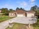 Exterior view of a well-manicured lawn, lovely landscaping, and a charming home with a three-car garage and stone accents at 10124 Southern Breeze Ct, Weeki Wachee, FL 34613