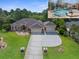 An exterior shot of a home with a well-manicured lawn, beautiful landscaping, and a screened-in pool at 10124 Southern Breeze Ct, Weeki Wachee, FL 34613
