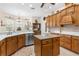 Bright eat-in kitchen features wood cabinetry, island, stainless appliances, and light countertops at 10124 Southern Breeze Ct, Weeki Wachee, FL 34613