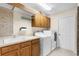 Bright laundry room featuring a utility sink, ample cabinet storage, and modern washer and dryer appliances at 10124 Southern Breeze Ct, Weeki Wachee, FL 34613