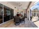 A covered outdoor patio area furnished with a dining table, chairs, a ceiling fan, and offering a relaxing space at 10124 Southern Breeze Ct, Weeki Wachee, FL 34613