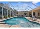 A screened-in pool area with clear blue water and lounge chairs at 10124 Southern Breeze Ct, Weeki Wachee, FL 34613