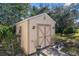 Exterior view of a well-maintained storage shed providing ample space for tools and equipment within lush greenery at 10124 Southern Breeze Ct, Weeki Wachee, FL 34613