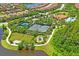 Aerial view of tennis courts, playground, and lush landscaping in a vibrant community at 11204 Egeria Dr, Odessa, FL 33556