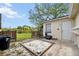 Backyard patio area with trash containers, sand box, and fenced area by small pond at 6920 Medlar Dr, New Port Richey, FL 34653