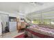 Bedroom with work desk, large windows, and a bed covered with a geometrically patterned red coverlet at 6920 Medlar Dr, New Port Richey, FL 34653