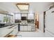 Bright kitchen features recessed lighting, window, white cabinetry, and full size fridge for convenient storage at 6920 Medlar Dr, New Port Richey, FL 34653