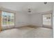 Bright main bedroom featuring neutral carpet, white walls, and a large window at 7830 Becket St, New Port Richey, FL 34653