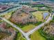 Aerial view showcasing the community's golf course, ponds, natural areas, roadways, and residential area in a scenic landscape at 8148 Ambersweet Pl, Land O Lakes, FL 34637