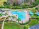 Aerial view of community pool with lounging areas and landscaping near a golf course at 8148 Ambersweet Pl, Land O Lakes, FL 34637
