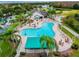 Aerial view of the community pool, surrounded by palm trees, lounge chairs, and patio furniture at 8148 Ambersweet Pl, Land O Lakes, FL 34637