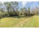 Large backyard with pond and mature trees on a sunny day at 1025 Ketzal Dr, Trinity, FL 34655