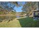 Serene backyard featuring a pond, mature trees, and lush green lawn extending to the water's edge at 11243 Merganser Way, New Port Richey, FL 34654