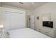 Bedroom with white closet doors, a dresser with a TV and views to another room at 11243 Merganser Way, New Port Richey, FL 34654