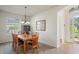 Cozy dining room features a wooden table with six chairs, chandelier lighting, and a decorative mirror at 11243 Merganser Way, New Port Richey, FL 34654