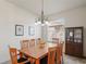 Bright dining room features a wooden table with six chairs, chandelier lighting, and a cabinet at 11243 Merganser Way, New Port Richey, FL 34654