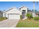Inviting single-story home with a two-car garage, screened front entry, and well-maintained lawn at 11243 Merganser Way, New Port Richey, FL 34654