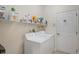 Bright laundry room features a washer and dryer with storage shelves, and a white door at 11243 Merganser Way, New Port Richey, FL 34654