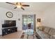 Bright living room with tile flooring, ceiling fan, and sliding glass doors leading to the screened patio at 11243 Merganser Way, New Port Richey, FL 34654