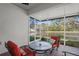 Relaxing screened porch features red patio furniture, a round table, and picturesque views at 11243 Merganser Way, New Port Richey, FL 34654