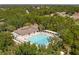 Aerial view of a community pool and clubhouse surrounded by mature trees at 13793 Dunwoody Dr, Spring Hill, FL 34609