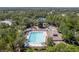 A large community pool with lounge chairs, umbrellas, and a playset surrounded by lots of trees at 13793 Dunwoody Dr, Spring Hill, FL 34609
