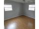 Bedroom featuring wood laminate floors and two windows at 4011 W Mango Ave, Tampa, FL 33616