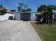 Driveway view of single-story house exterior with landscaping and white fence at 4011 W Mango Ave, Tampa, FL 33616