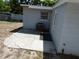 View of the home's exterior corner with a patio, AC unit, window, and landscaping at 4011 W Mango Ave, Tampa, FL 33616