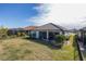 Wide backyard with a peek at a screened in porch and neighboring homes with tile roofs at 11061 Egeria Dr, Odessa, FL 33556