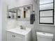 Well-lit bathroom featuring a modern vanity, mirror, and toilet, with neutral walls and fixtures at 12529 Shadow Ridge Blvd, Hudson, FL 34669