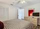 Cozy bedroom with neutral decor, including a dresser with a mirror and TV, and double closet doors at 12529 Shadow Ridge Blvd, Hudson, FL 34669