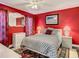 Cozy bedroom with a ceiling fan, bright red walls and neutral colored furniture at 12529 Shadow Ridge Blvd, Hudson, FL 34669