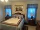 Comfortable bedroom with coordinated blue and brown bedding, matching curtains, and framed artwork at 12529 Shadow Ridge Blvd, Hudson, FL 34669