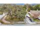 Beautiful front yard with mature trees, landscape, and a driveway containing multiple vehicles and a boat on a trailer at 12529 Shadow Ridge Blvd, Hudson, FL 34669